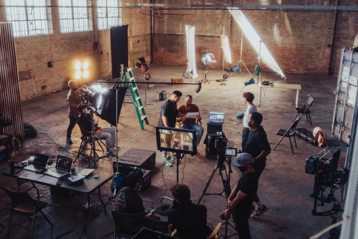Film crew and photographers gathered on set with cameras and lighting equipment